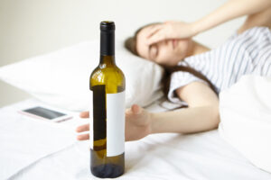 vrouw met fles wijn in bed